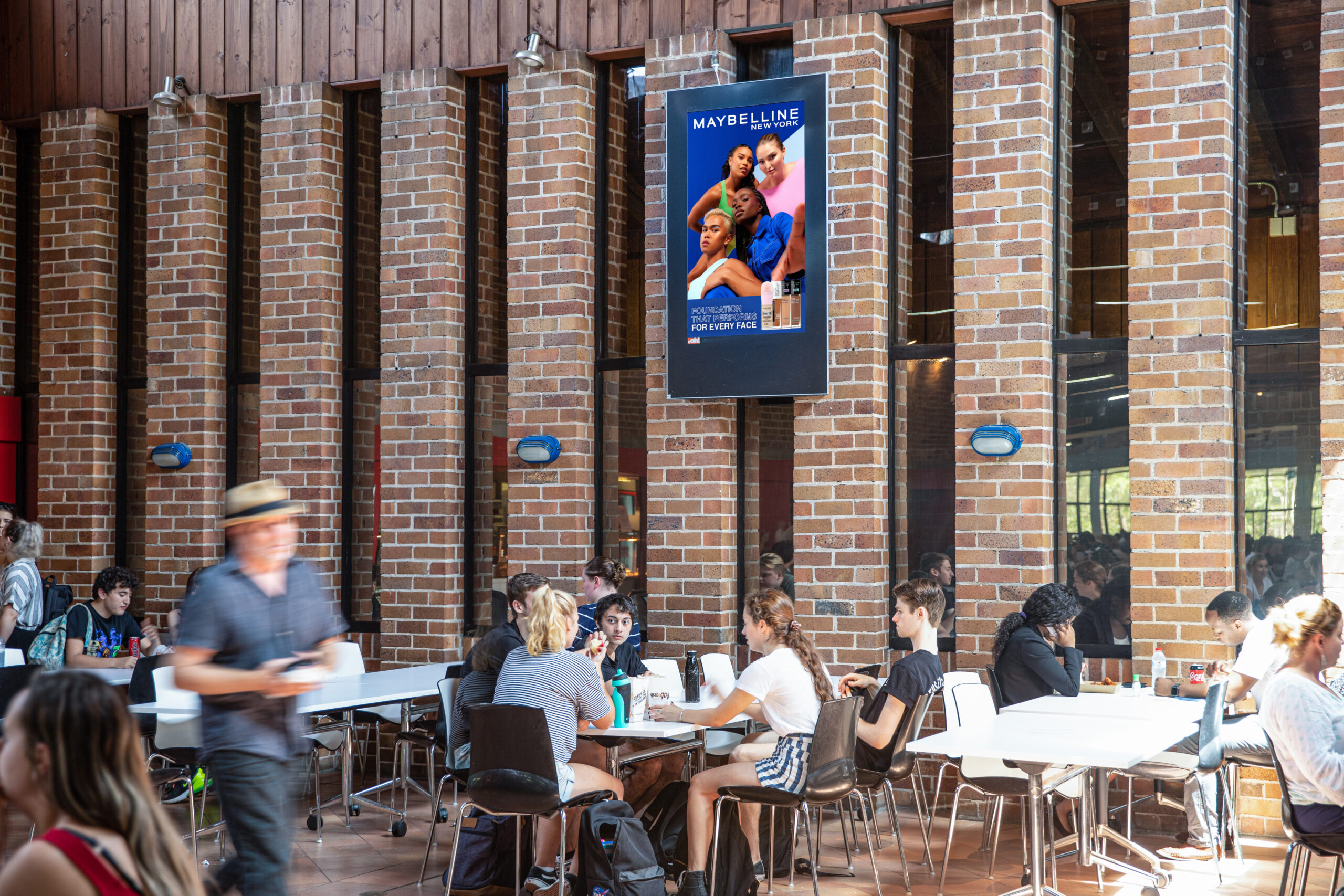 Digital advertising screen in university, Australia, featuring Maybelline advertisement
