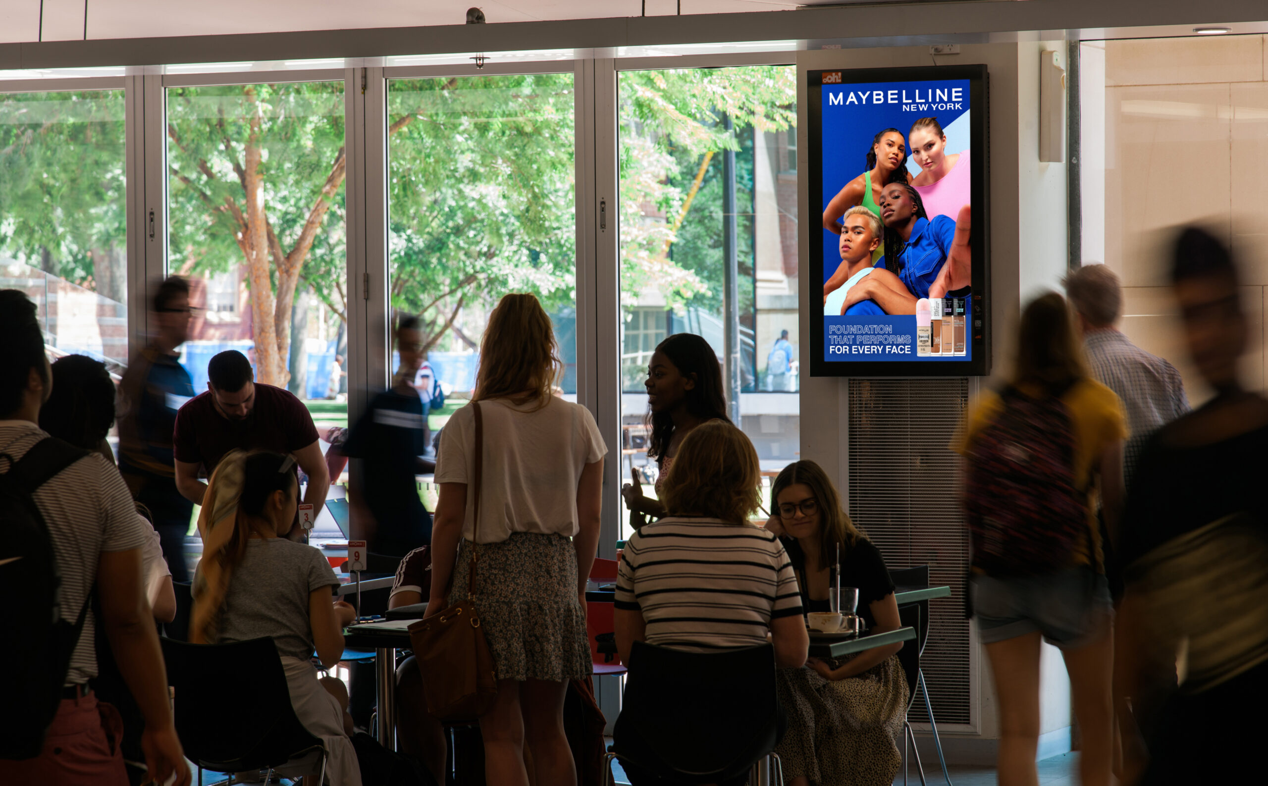 Digital advertising screen in university, Australia, featuring Maybelline advertisement