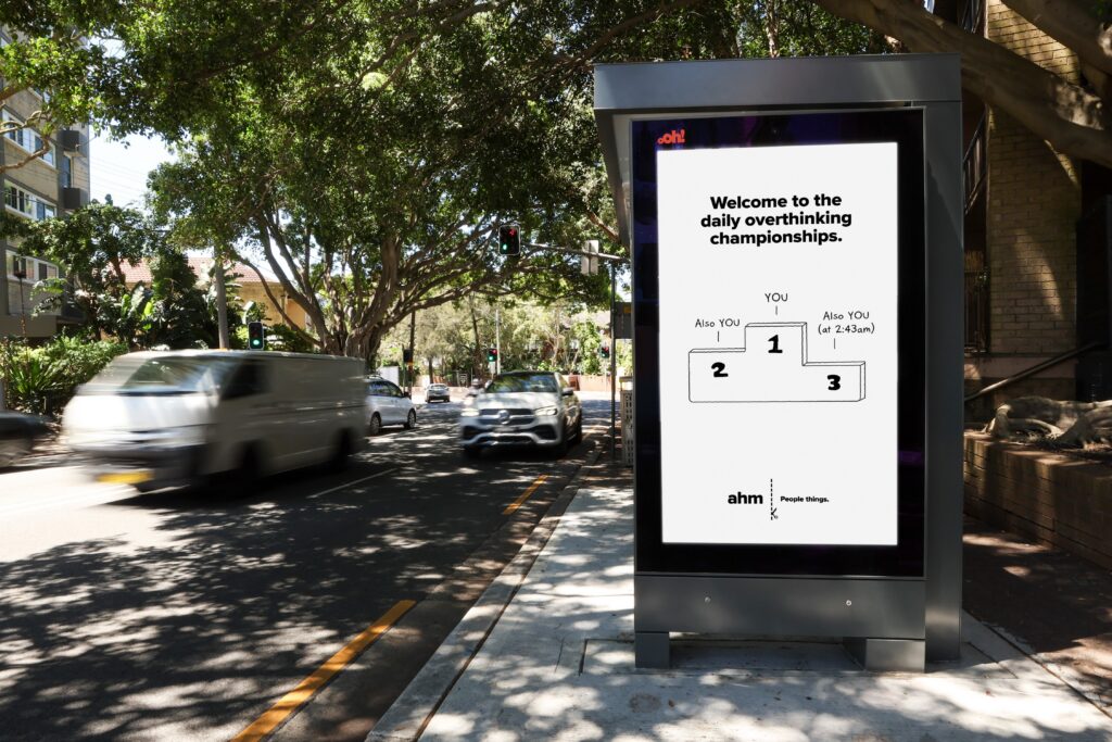 Street furniture bus shelter digital advertising panel in Bondi Junction, featuring ahm insurance creative